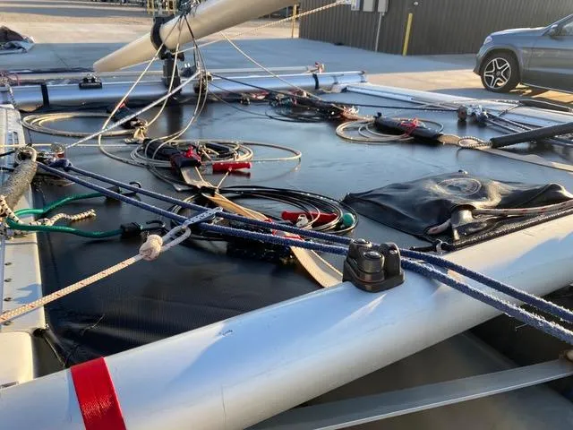1989 Nacra 5.8 catamaran deck with rigging and ropes in a parking area.