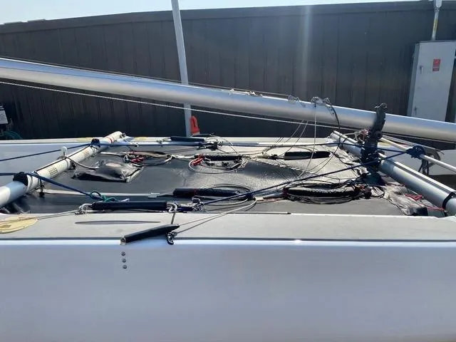 1989 Nacra 5.8 sailboat deck with rigging and mast, outdoor setting.