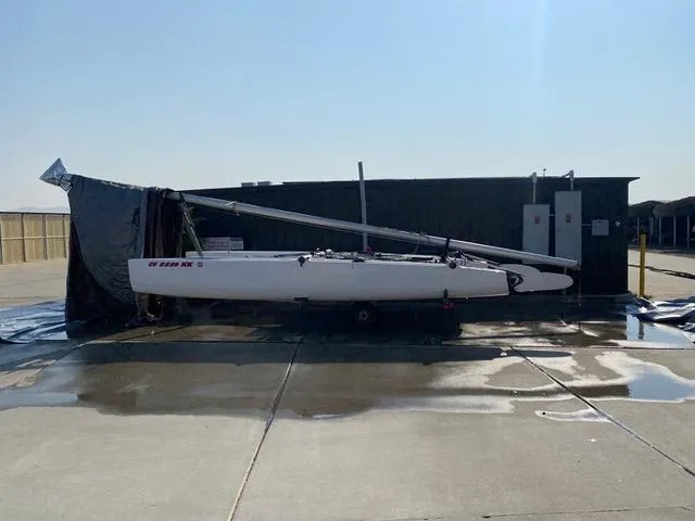 1989 Nacra 5.8 catamaran stored outdoors on a sunny day.