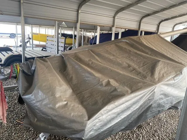 Covered 1989 Nacra 5.8 sailboat stored in a sheltered area.