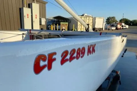 1989 Nacra 5.8 catamaran with registration CF 2289 KK, docked outdoors.