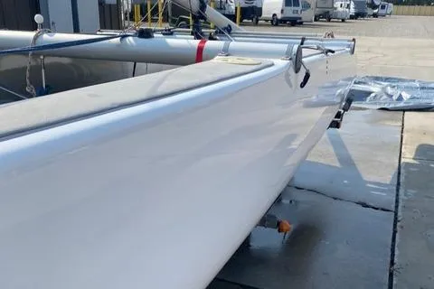 1989 Nacra 5.8 catamaran on trailer, parked outdoors, side view.