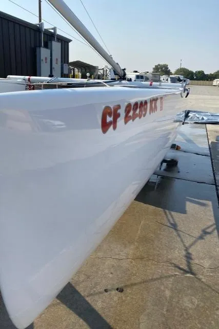 1989 Nacra 5.8 sailboat on a wet dock, side view.