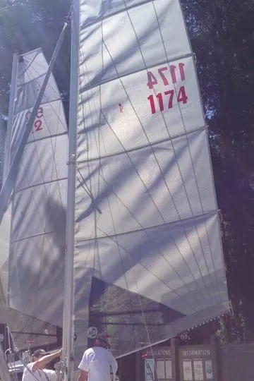Sailboat with Nacra 5.8 sails, 1989 model, docked with people adjusting rigging.