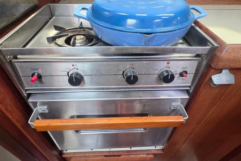Stainless steel stove with blue pot on a 1995 Hunter 336 sailboat.