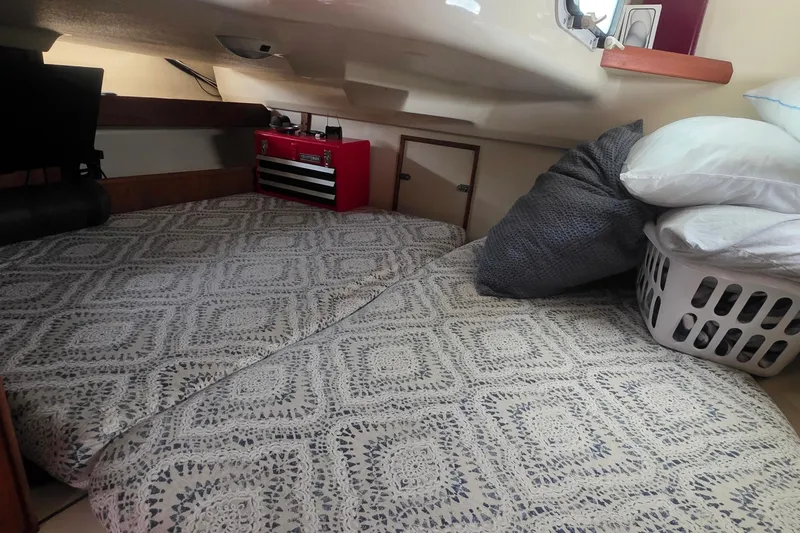 Cozy cabin interior of 1995 Hunter 336 sailboat with bedding and storage.