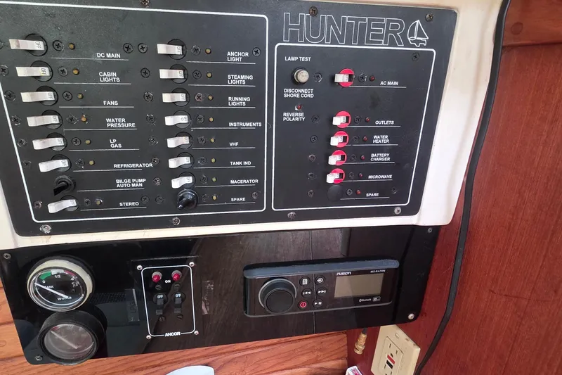 Control panel of a 1995 Hunter 336 sailboat with various switches and gauges.