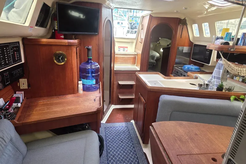 Interior of a 1995 Hunter 336 sailboat featuring a cozy kitchen and seating area.