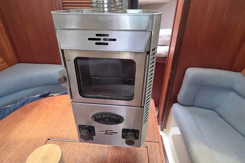 Stainless steel stove in 1995 Hunter 336 yacht interior, featuring cozy seating and wooden accents.