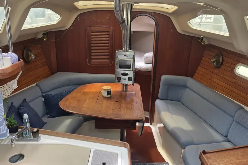 Interior of a 1995 Hunter 336 sailboat with cozy seating and wooden accents.