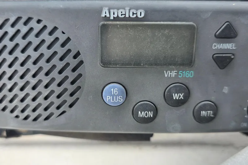 Close-up of Apelco VHF 5160 marine radio with control buttons and speaker grille.