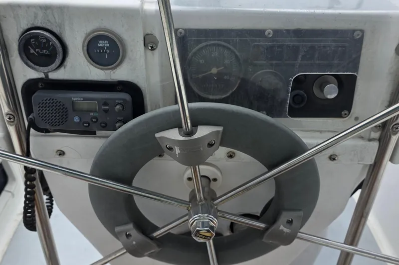 Steering wheel and controls of a 1995 Hunter 336 sailboat cockpit.