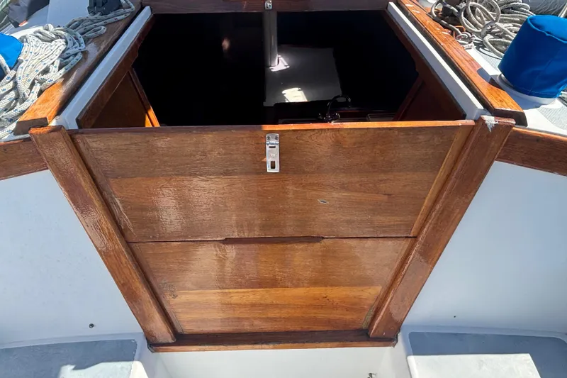 Wooden hatch entrance on a 1988 Catalina 34 sailboat deck, surrounded by ropes.