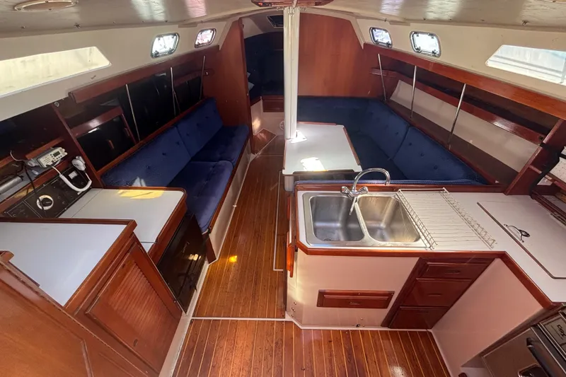 Interior of a 1988 Catalina 34 sailboat with wood finish and blue seating.