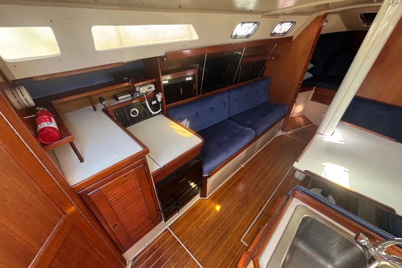 1988 Catalina 34 yacht interior with wood finish, blue seating, and navigation equipment.