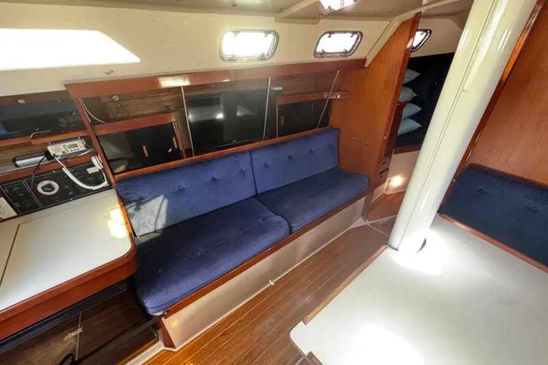 Interior of a 1988 Catalina 34 sailboat with blue seating and wooden accents.
