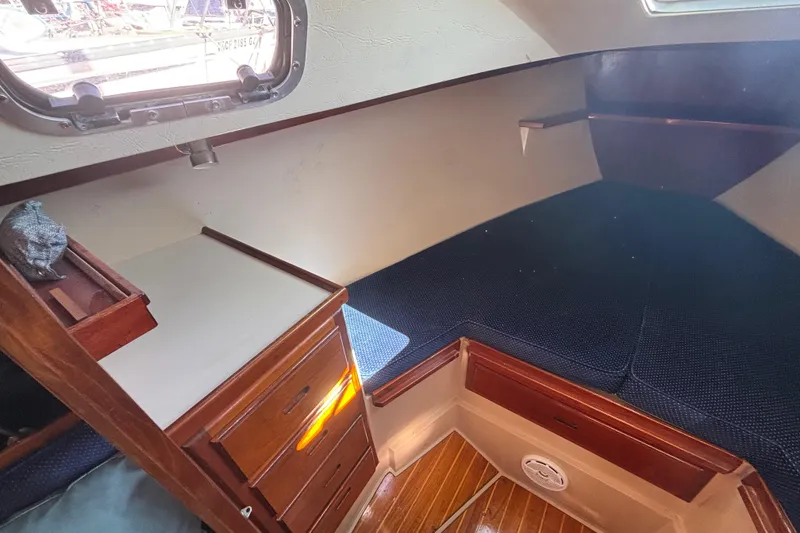 1988 Catalina 34 sailboat interior with wooden cabinetry and cozy sleeping area.