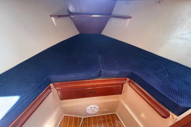 1988 Catalina 34 sailboat interior cabin with blue cushions and wooden accents.
