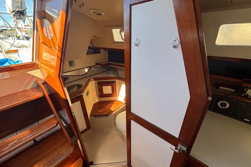 Interior of a 1988 Catalina 34 sailboat, featuring wooden cabinetry and compact design.
