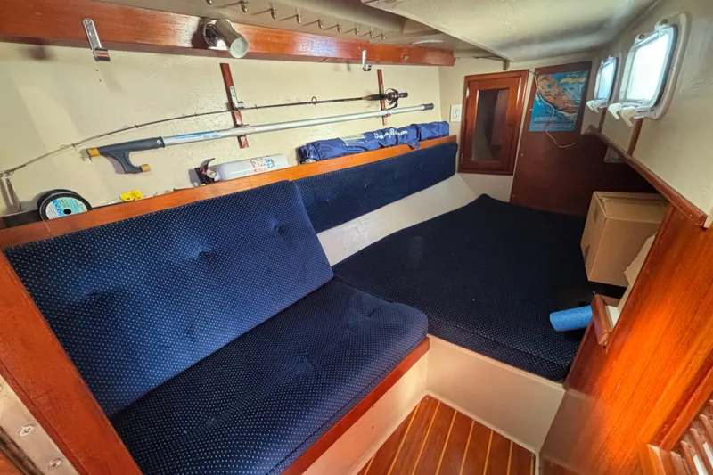 1988 Catalina 34 sailboat interior with blue cushions and wooden accents.