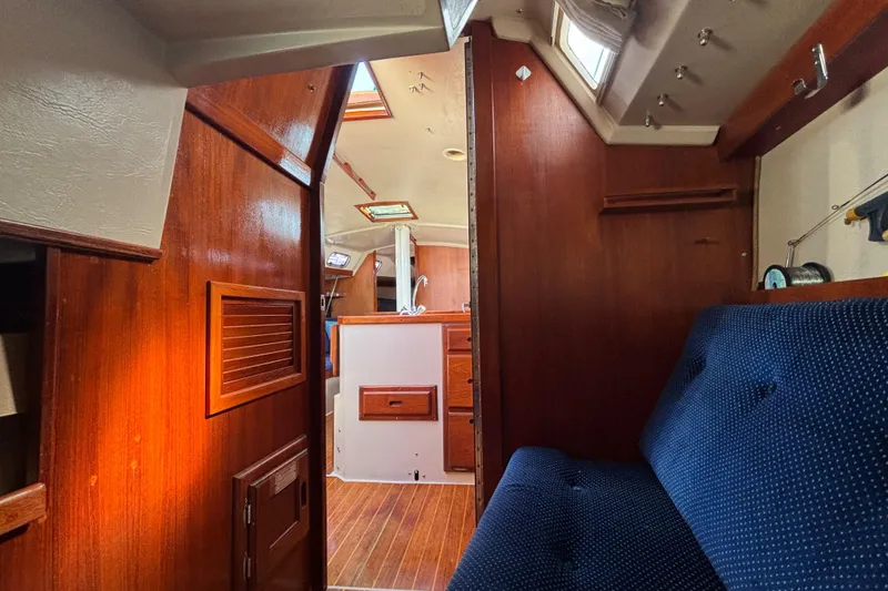 Interior of a 1988 Catalina 34 sailboat with wood paneling and blue upholstery.