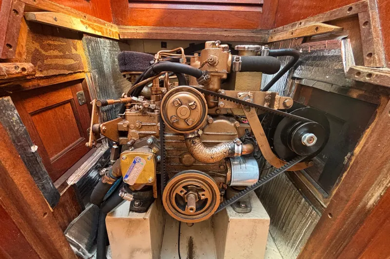 Engine of a 1988 Catalina 34 sailboat, showcasing mechanical components and belts.
