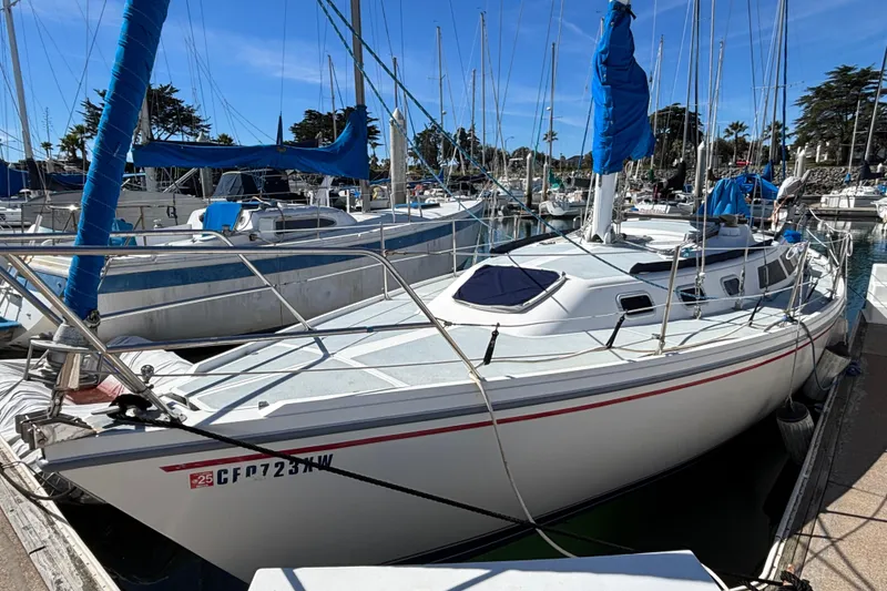 1988 Catalina 34 sailboat docked in a marina, featuring blue sails and a sleek design.