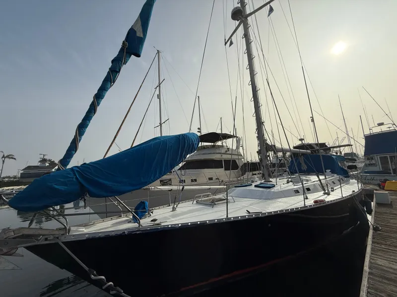 1986 Beneteau Idylle 15.50 sailboat docked at marina under a cloudy sky.