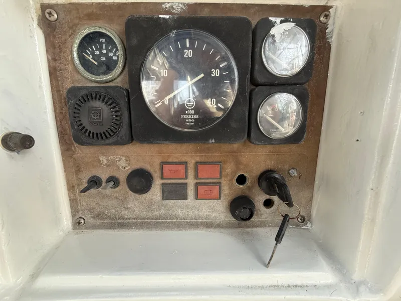 Control panel of a 1986 Beneteau Idylle 15.50 sailboat with gauges and switches.