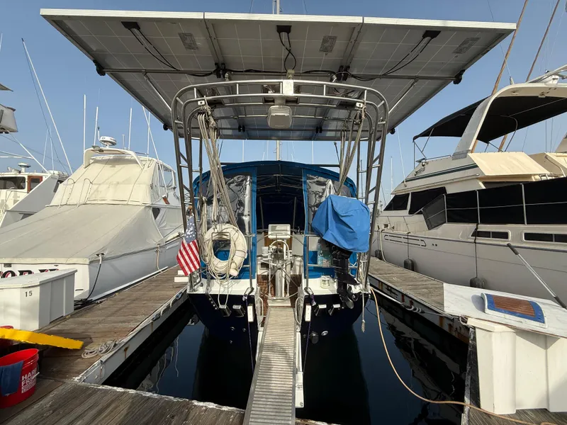 Beneteau Idylle 15.50 sailboat, 1986 model, docked with solar panels and American flag.