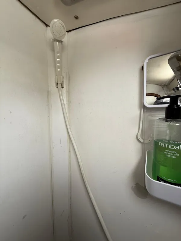 Shower area in 1986 Beneteau Idylle 15.50 yacht with soap dispenser and mirror.