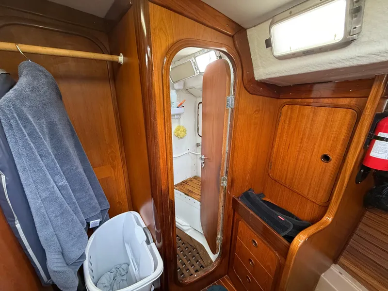 Interior of 1986 Beneteau Idylle 15.50 sailboat with wooden cabinetry and bathroom view.