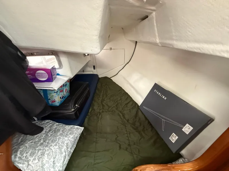 Cozy cabin interior of 1986 Beneteau Idylle 15.50 with bedding and storage items.