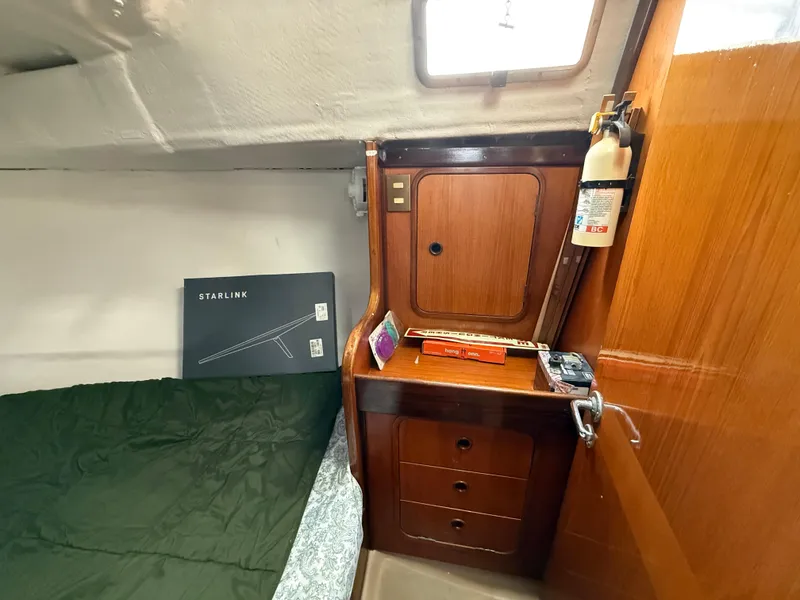 Cabin interior of 1986 Beneteau Idylle 15.50 with wooden cabinetry and Starlink box.