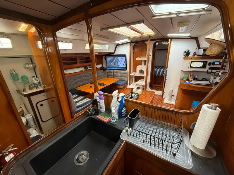 Interior of 1986 Beneteau Idylle 15.50 yacht with kitchen, dining area, and cozy living space.