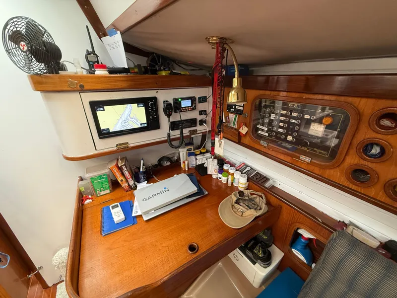 Navigation station on a 1986 Beneteau Idylle 15.50 yacht with equipment and charts.