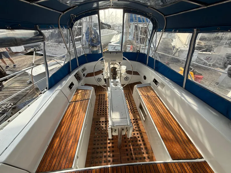 Cockpit of 1986 Beneteau Idylle 15.50 sailboat with wooden seating and steering wheel.