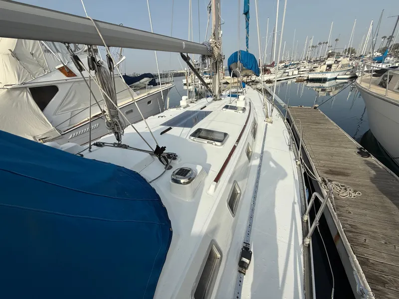 1986 Beneteau Idylle 15.50 sailboat docked at marina, featuring blue covers and sleek design.