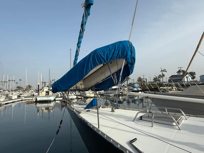 1986 Beneteau Idylle 15.50 sailboat docked in marina, blue sail cover visible.