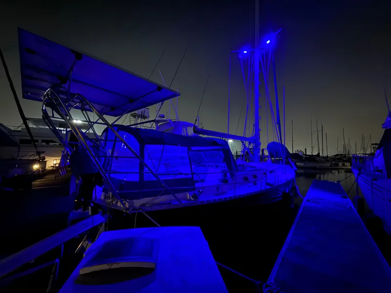 Sailboat Beneteau Idylle 15.50, 1986 model, illuminated at night in marina.