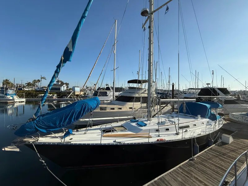 1986 Beneteau Idylle 15.50 sailboat docked in a marina under clear skies.