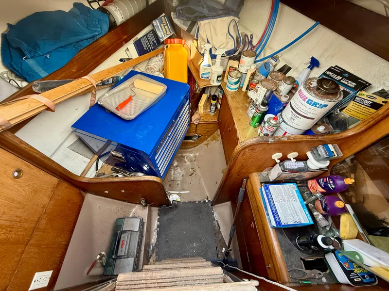 Interior of 1986 Beneteau Idylle 15.50 sailboat with tools and supplies stored.