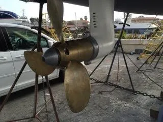 Propeller of 2002 X-Yachts X-382 sailboat on dry dock, showcasing bronze blades.