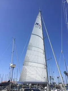 2002 X-Yachts X-382 sailboat with tall mast in marina under clear blue sky.