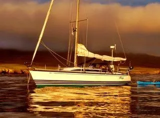 2002 X-Yachts X-382 sailboat on calm water at sunset.