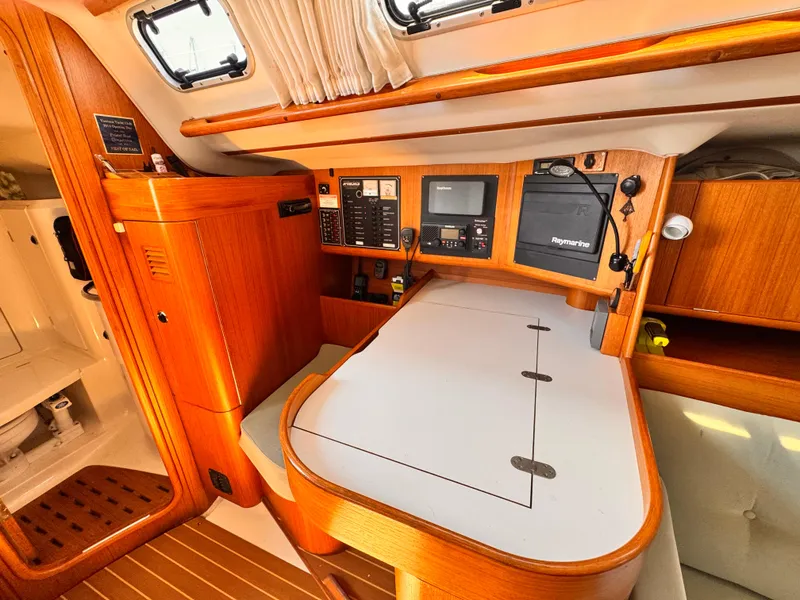 Interior of 2002 X-Yachts X-382 sailboat with navigation station and wooden cabinetry.