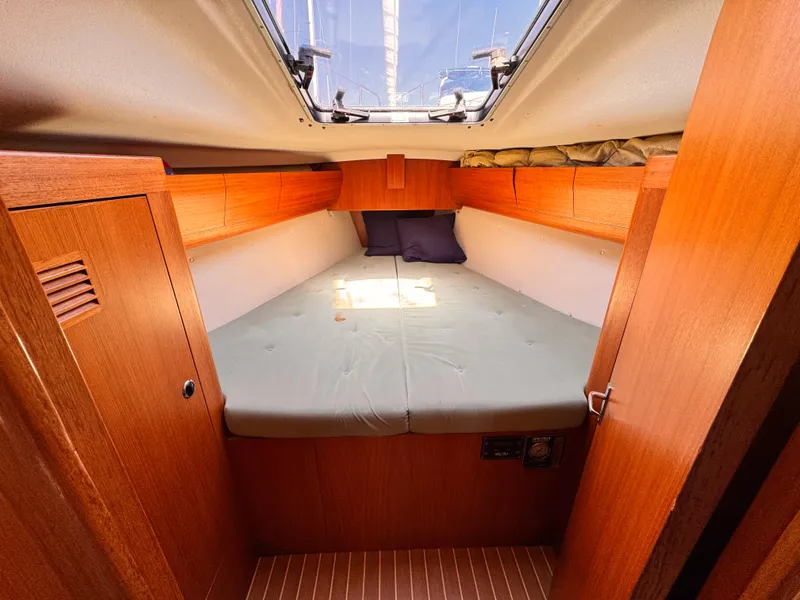 Cozy cabin interior of 2002 X-Yachts X-382 sailboat with wooden finish and skylight.