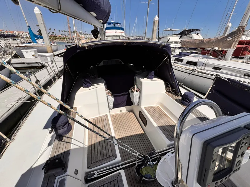 Cockpit of 2002 X-Yachts X-382 sailboat docked at marina, featuring teak flooring and navigation equipment.