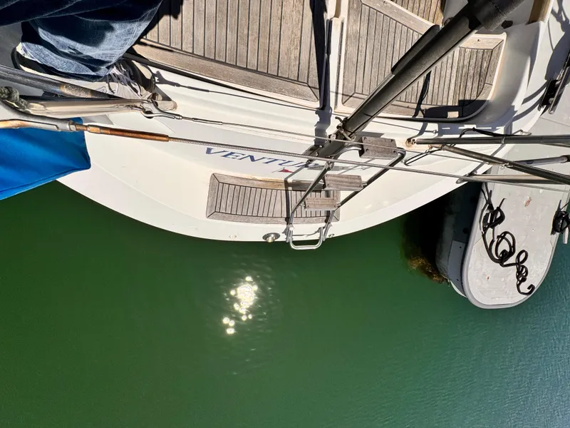 Top view of 2002 X-Yachts X-382 sailboat docked on calm green water.