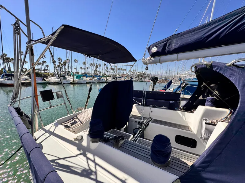2002 X-Yachts X-382 sailboat with blue covers, docked in a sunny marina.